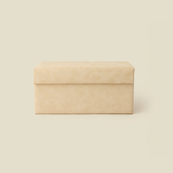 A rectangular cream leather storage box with a hinged lid, shown against a solid light beige background.