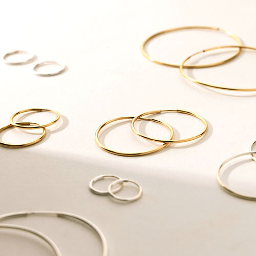 A flat lay of Live In Hoops earrings in several sizes.