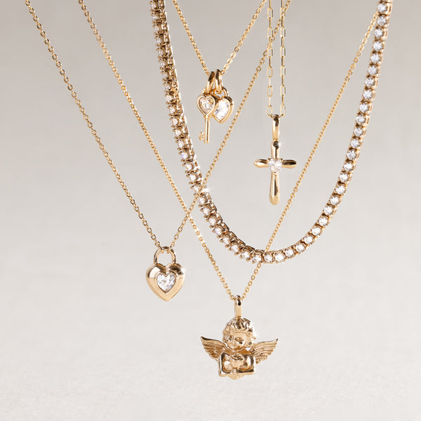 Gold necklaces with various pendants on a light gray background