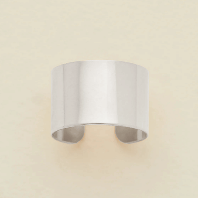 A minimalist, wide band ring in a polished silver finish, displayed against a clean, off-white background.