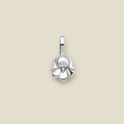 A polished silver lily of the valley flower charm, shown on a solid light beige background.