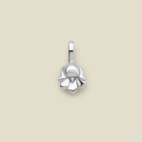 A polished silver lily of the valley flower charm, shown on a solid light beige background.