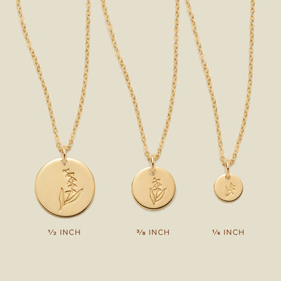 Three gold pendant necklaces, each with a different size of round flat disc and engraved with varying lily of the valley flower designs. Below the necklaces there is the text '1/2 INCH', '3/8 INCH', and '1/4 INCH'.