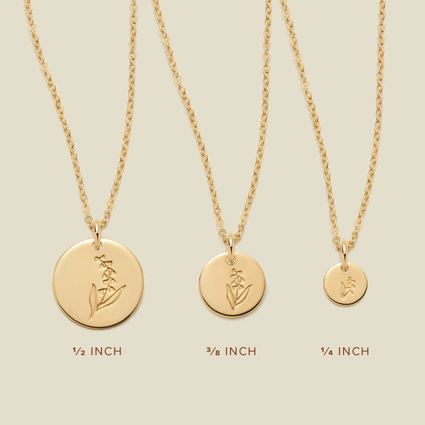 Three gold pendant necklaces, each with a different size of round flat disc and engraved with varying lily of the valley flower designs. Below the necklaces there is the text '1/2 INCH', '3/8 INCH', and '1/4 INCH'.