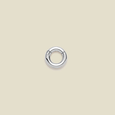 A polished silver round ring necklace attachment, shown on a solid light beige background.