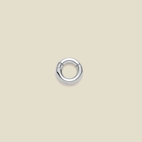 A polished silver round ring necklace attachment, shown on a solid light beige background.