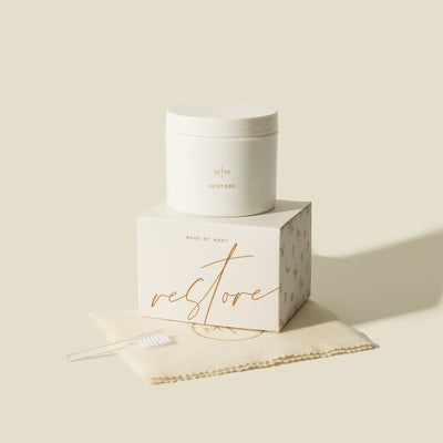 Restore jewelry cleaner jar and box with a small cleaning brush on a cream cloth.